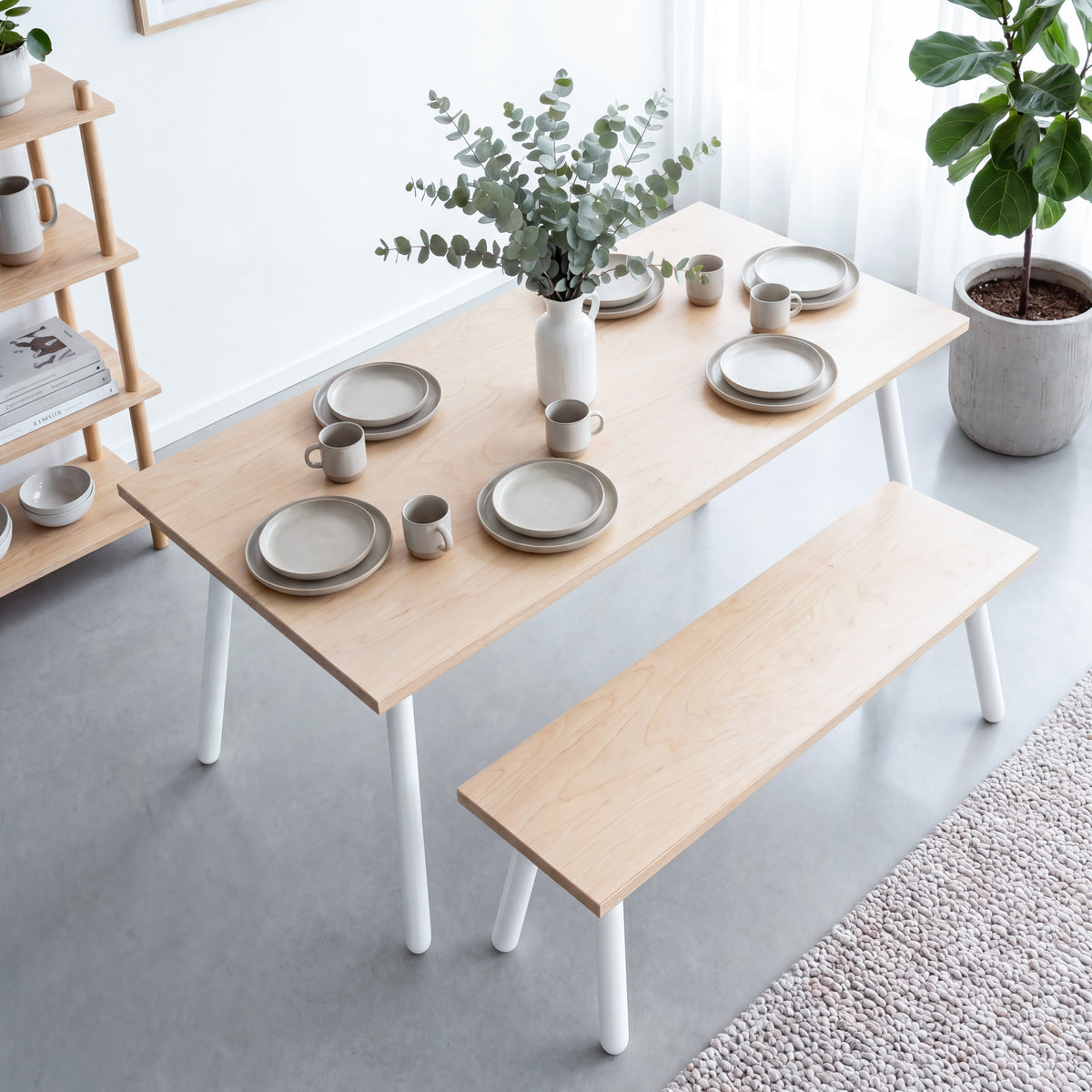 Birch plywood dining table and matching bench with white round Single Pin legs, viewed from above