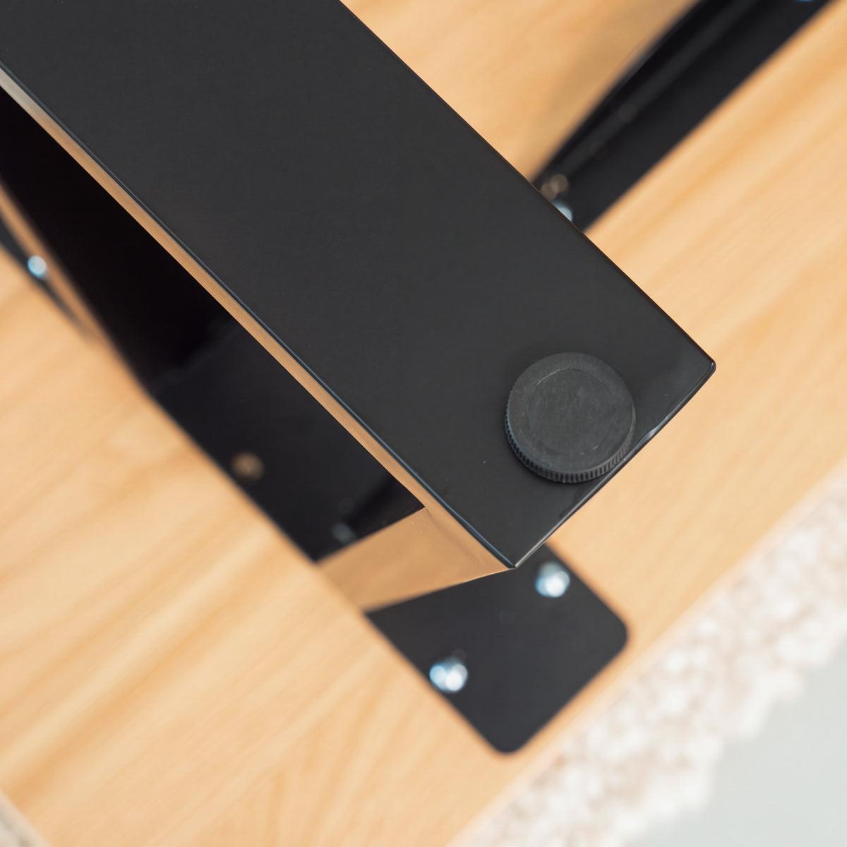 Close-up of the round foot beneath a black Trapezium dining table leg